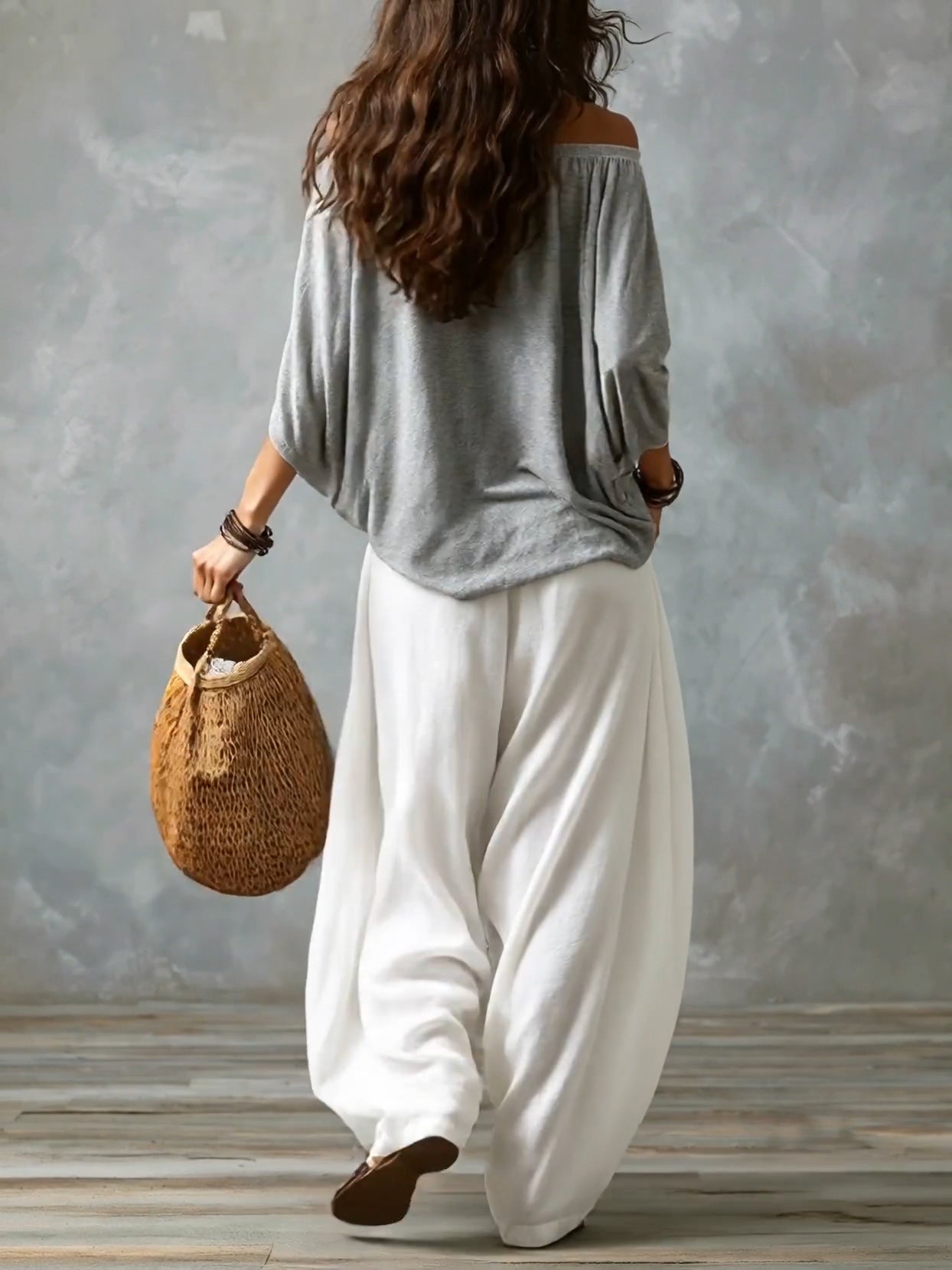 Blusa gris de hombros al aire y pantalones blancos de pierna acampanada