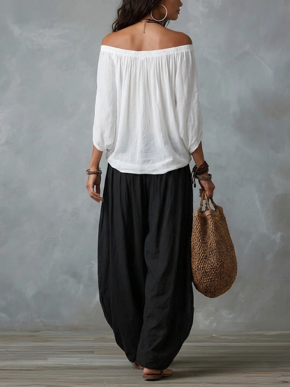 Blusa blanca con hombros descubiertos y pantalones de corte ancho estilo linterna
