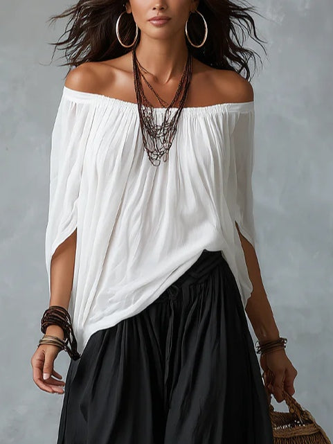 Blusa blanca con hombros descubiertos y pantalones de corte ancho estilo linterna