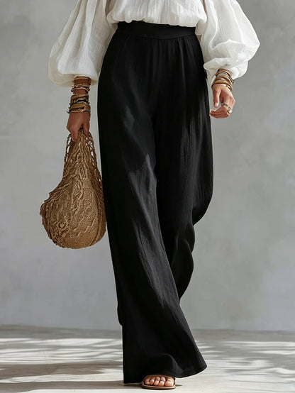 Conjunto de blusa blanca sin mangas y pantalones negros de pierna ancha