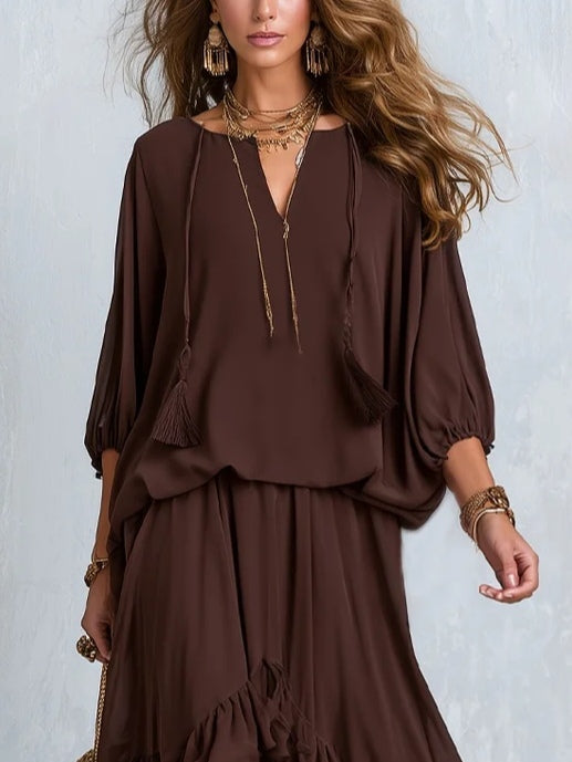Blusa de gasa marrón con escote en V y flecos, acompañada de un conjunto de falda de capas con volantes