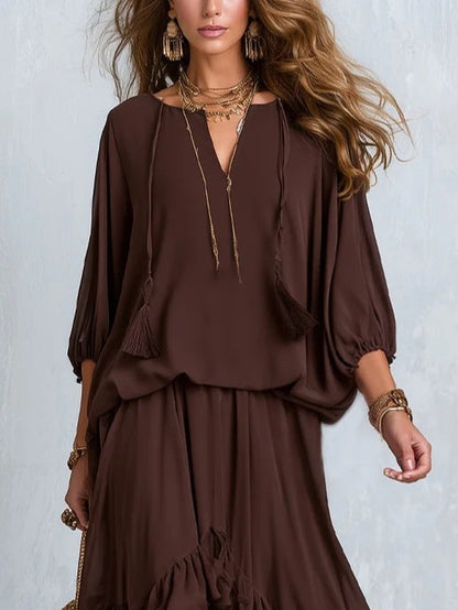 Blusa de gasa marrón con escote en V y flecos, acompañada de un conjunto de falda de capas con volantes